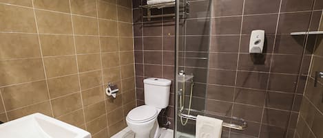Un baño moderno con inodoro, ducha y lavamanos.