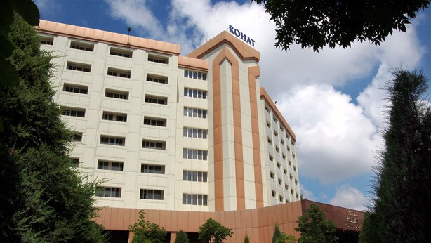 A hotel with a modern design, featuring a prominent 'ROHAT' sign on the top. - Rohat Hotel (Tashkent)