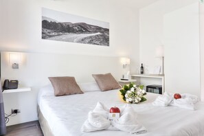Relax in a stylishly designed room with a comfortable bed, bedside table, and elegant decor.