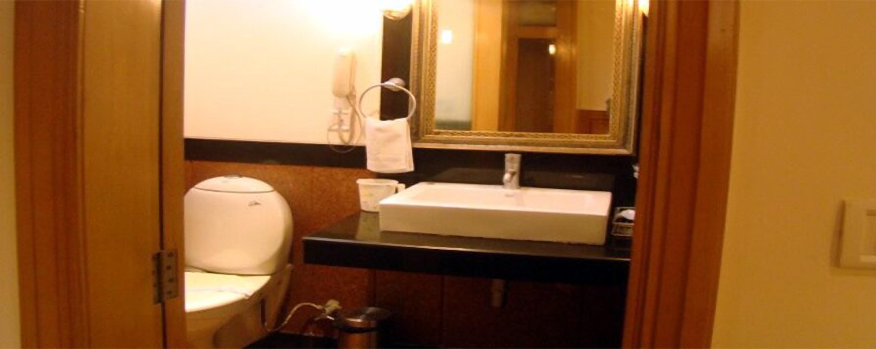 Un baño pequeño con inodoro, lavamanos y espejo.