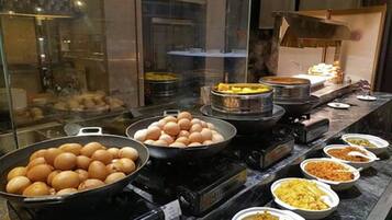 Un buffet con diversi piatti, tra cui uova, patate e preparazioni miste.