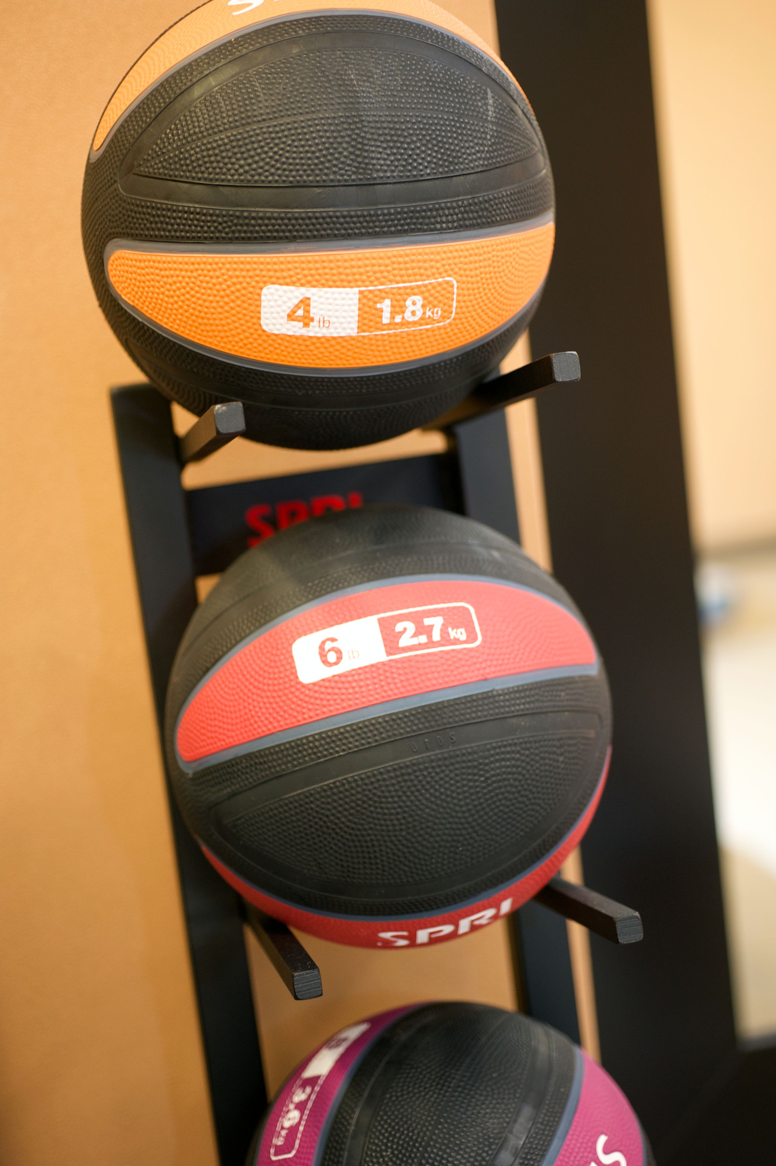 A rack holding three basketballs with visible weight labels.