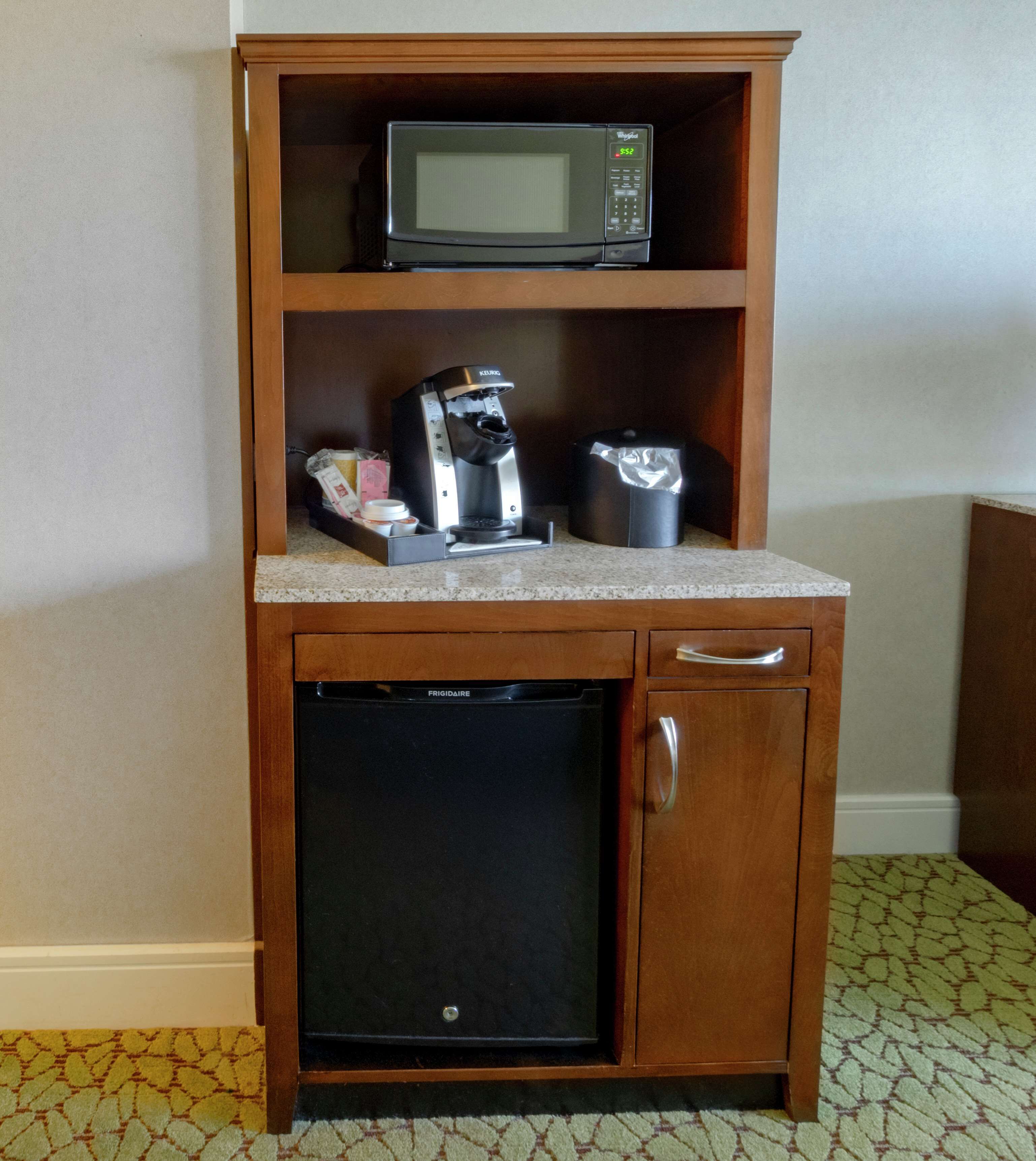 A compact kitchenette with a microwave, coffee maker, and mini-fridge.