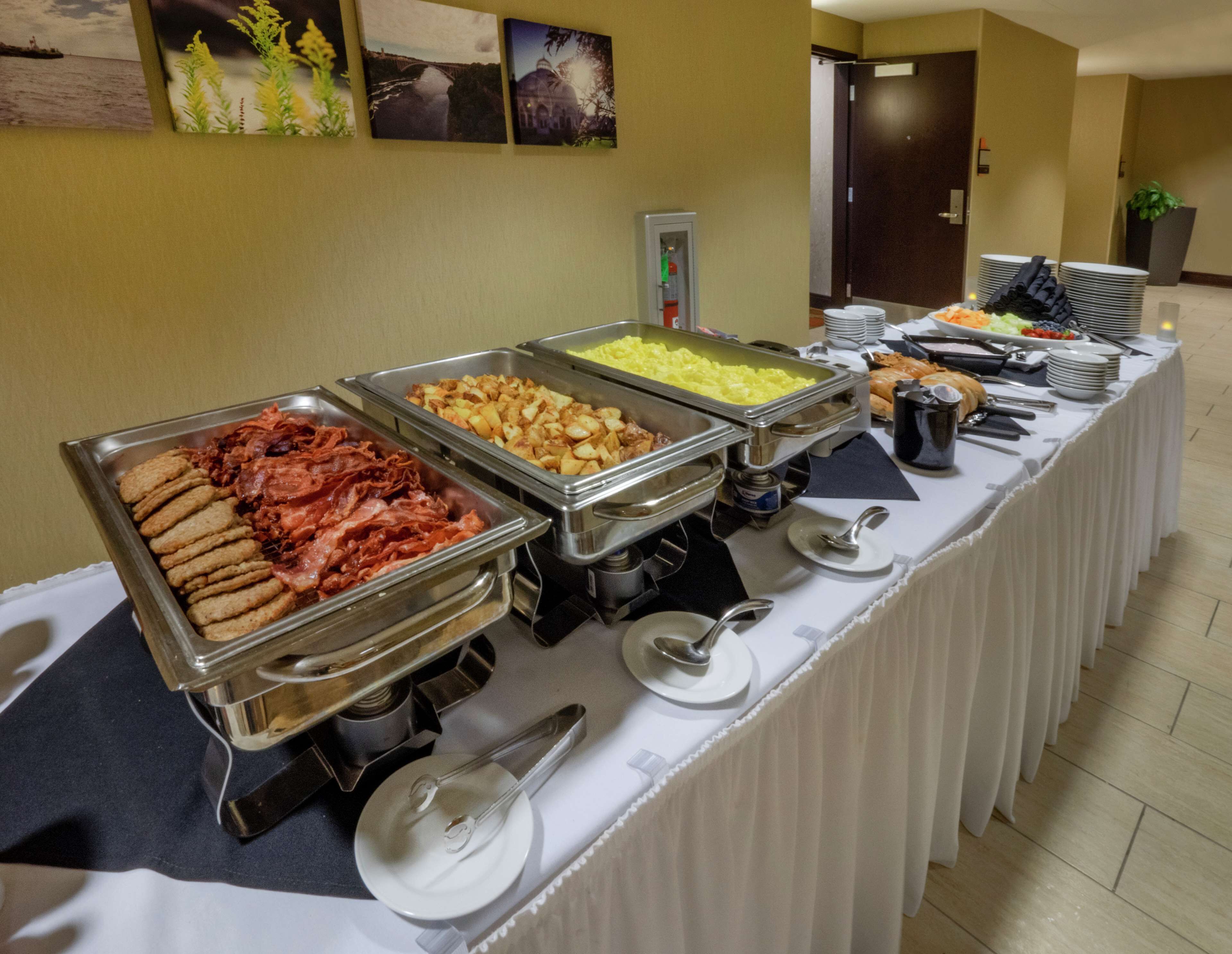 A buffet table with various food options, including meats, potatoes, and other dishes, in a hotel setting.