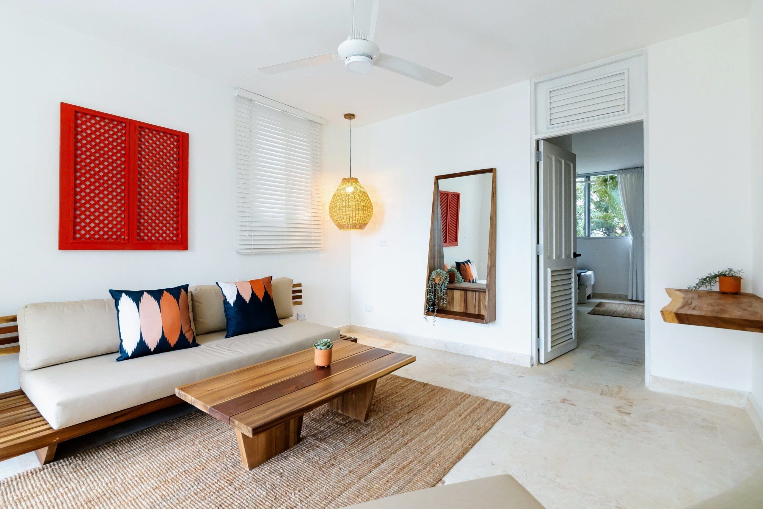 Un salon moderne avec un canapé, une table basse et un ventilateur de plafond.