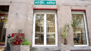 A building with a sign reading "Hôtel Aero" above the entrance. There are two potted plants in front of the entrance. - Aéro Club (Issy-les-Moulineaux)