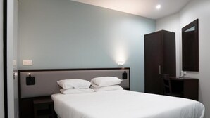 A hotel room with a large bed, a nightstand, a wardrobe, and a mirror. - Aéro Club (Issy-les-Moulineaux)