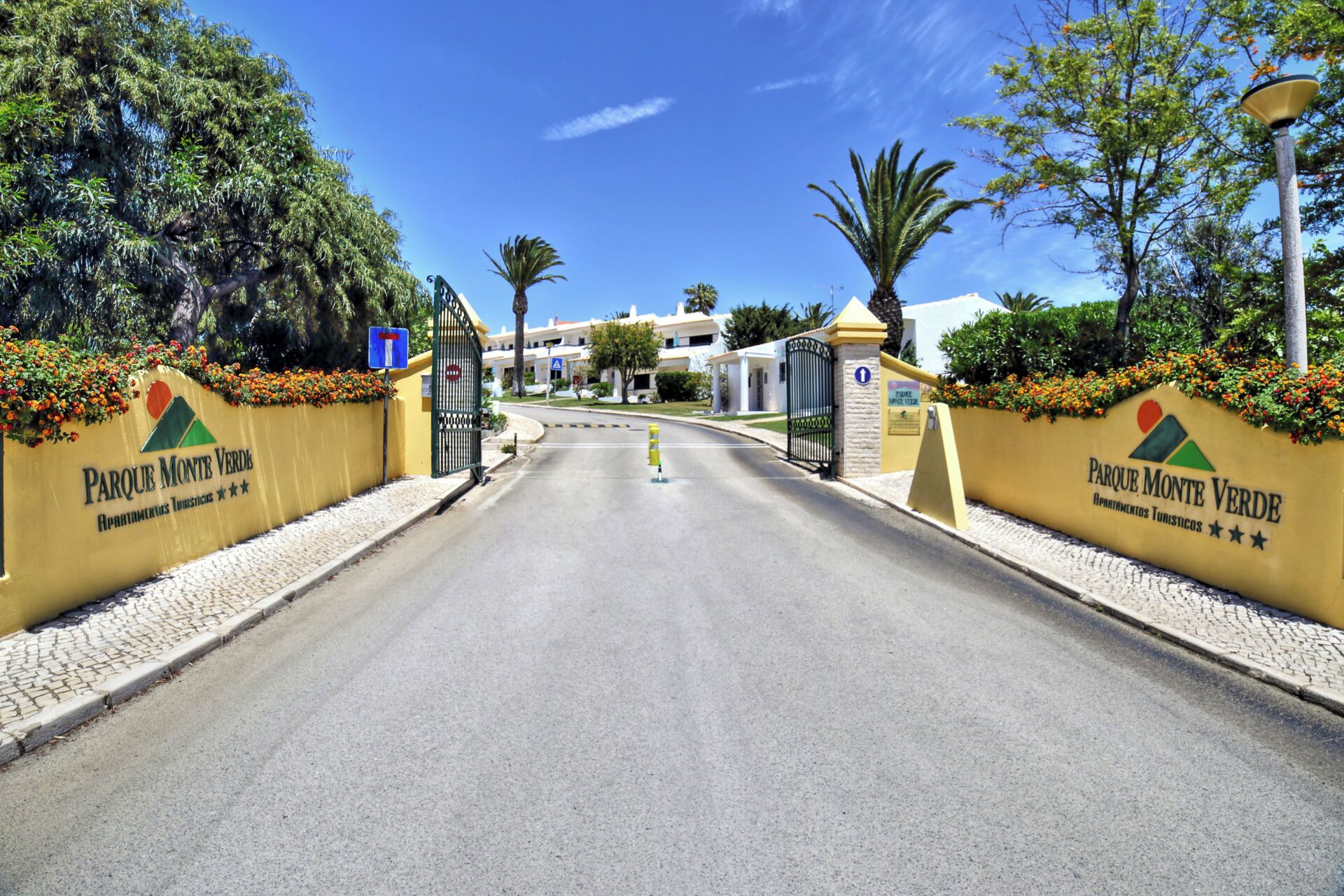 A gated entrance to Parque Monte Verde with a clear road leading to the property.