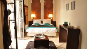 A hotel room with a bed, two bedside lamps, a bedside table, a desk, and a chair. - Le Riad Jardin Des Rêves By La Siredrah (Marrakech)