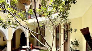 A courtyard with a pool, seating areas, and a large tree in the center. - Le Riad Jardin Des Rêves By La Siredrah (Marrakech)