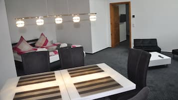 Een moderne hotelkamer met een bed, een eettafel en een bank.