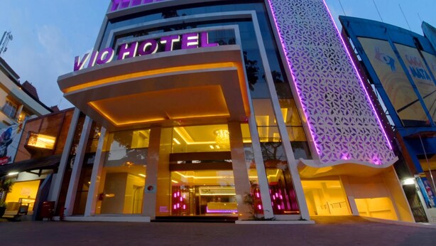 Un hôtel doté d’une façade moderne, d’une entrée imposante et d’une enseigne lumineuse.