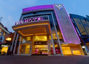 A hotel with a modern facade, a prominent entrance, and illuminated signage. - Vio Cihampelas (Bandung)