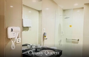 A modern bathroom with a hairdryer, towel rack, and a glass shower enclosure. - Vio Cihampelas (Bandung)