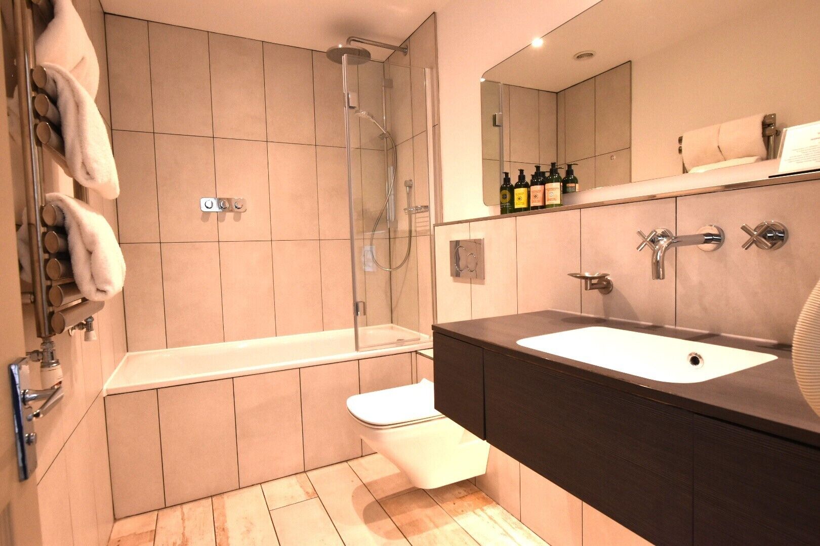 A modern bathroom with a bathtub, shower, and sink.