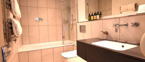 Un baño moderno con bañera, ducha y lavamanos.