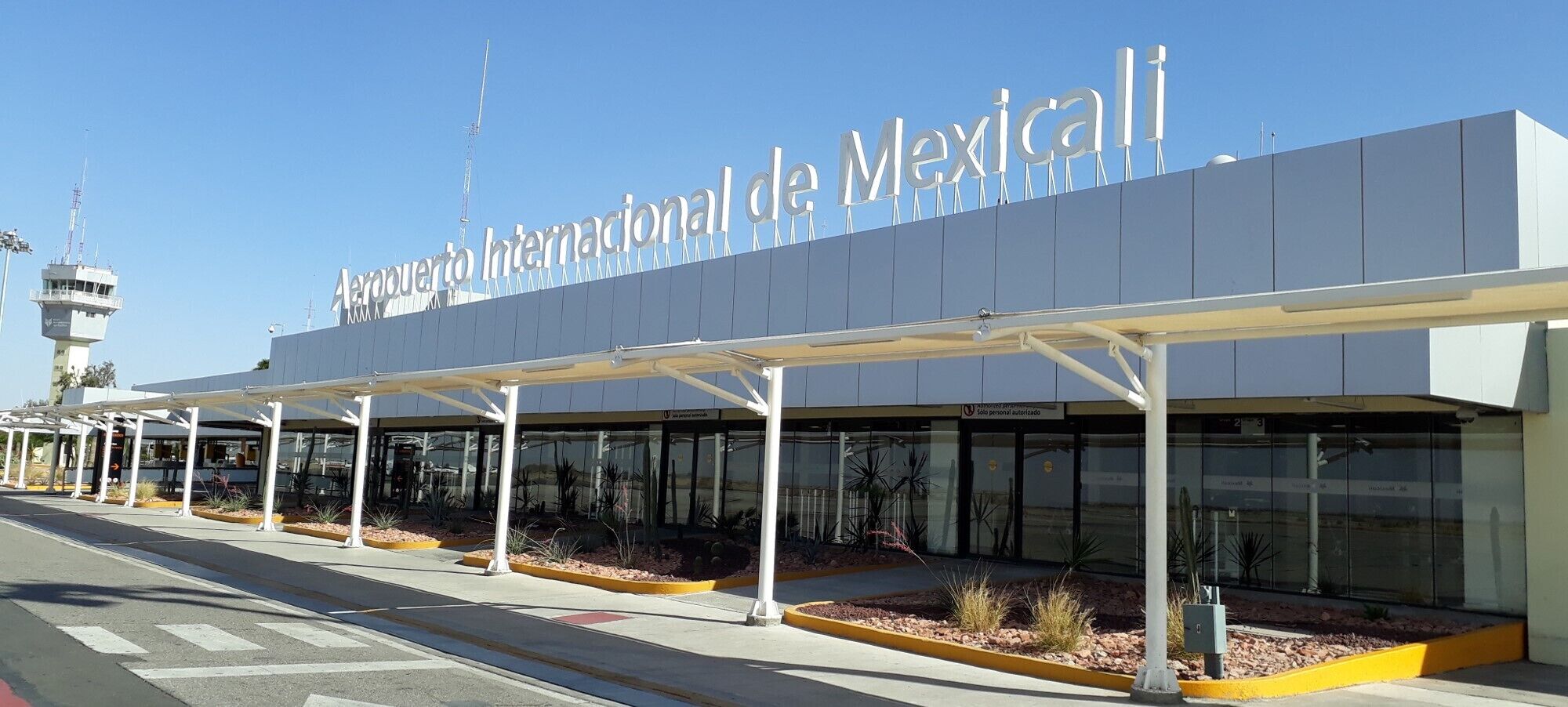 The exterior of the International Airport de Mexico with a clear sky.