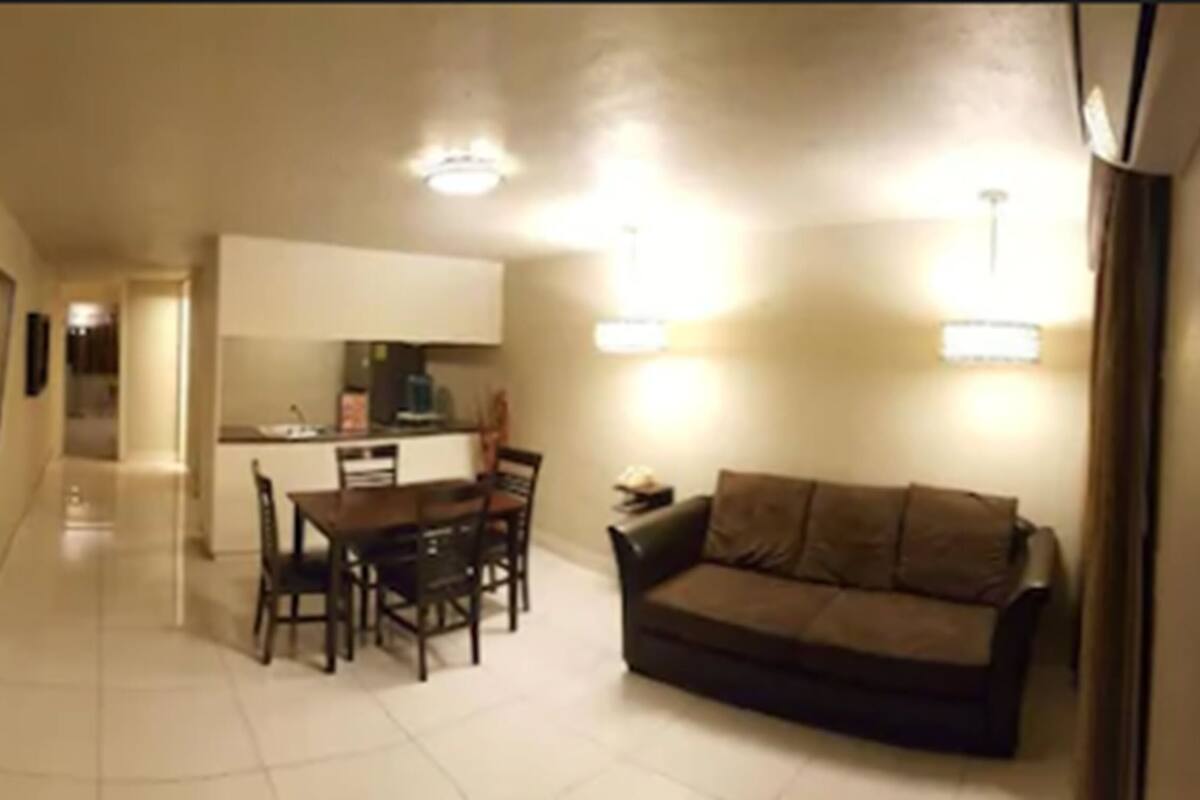 A compact living space with a dining area, a sofa, and a kitchenette.