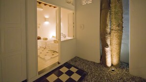 A hallway with a checkered floor leading to a room with a bed and a nightstand. - La Casa Del Piano Hotel Boutique by Xarm Hotels (Santa Marta)