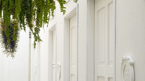 A row of white doors with a small plaque indicating room numbers. - La Casa Del Piano Hotel Boutique by Xarm Hotels (Santa Marta)