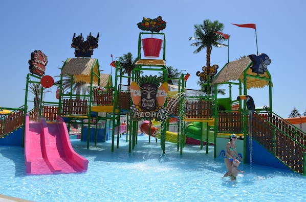 Parque acuático con toboganes, un área de juegos y una piscina.