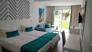 A hotel room with two beds, a sofa, a dining table, and a large window with a view of the outdoors. - Thalassa Sousse Resort & Aquapark (Sousse)