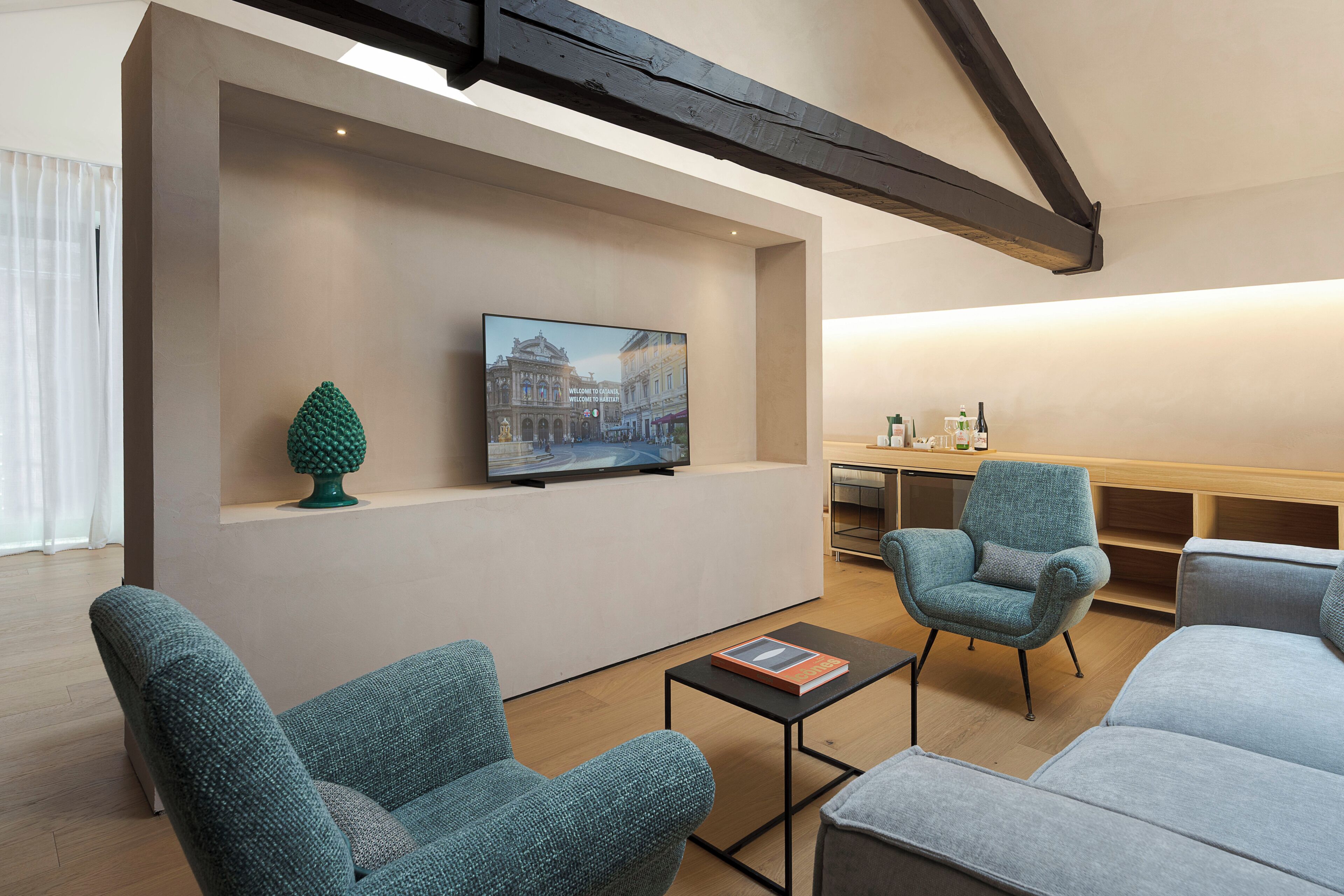 A modern living room with a television mounted on a wall, a small table, and two sofas.