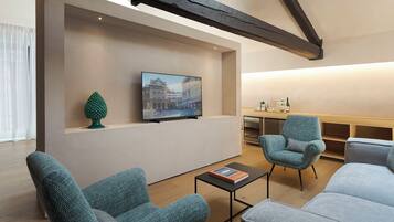 A modern living room with a television mounted on a wall, a small table, and two sofas.
