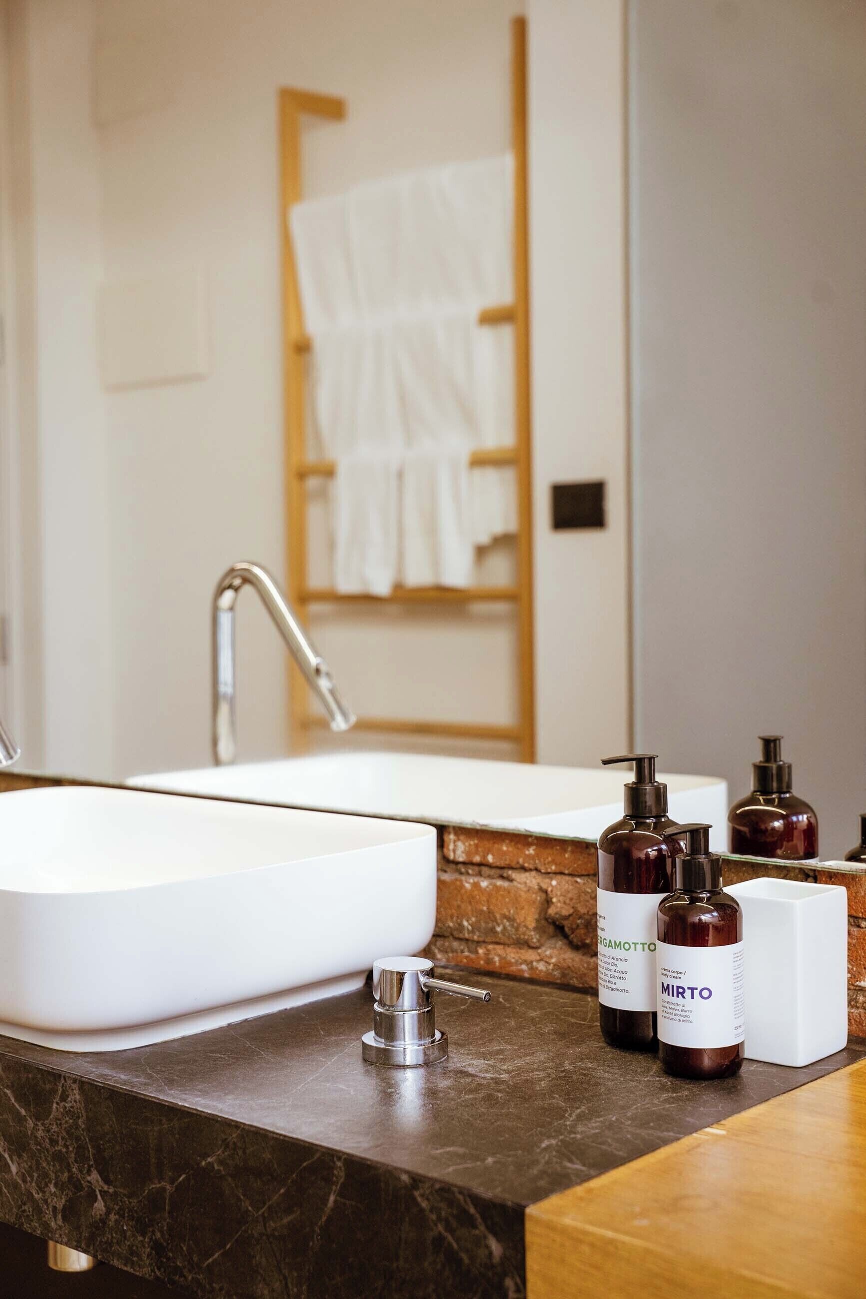 A bathroom with a white sink, a mirror, and two bottles of hand soap.