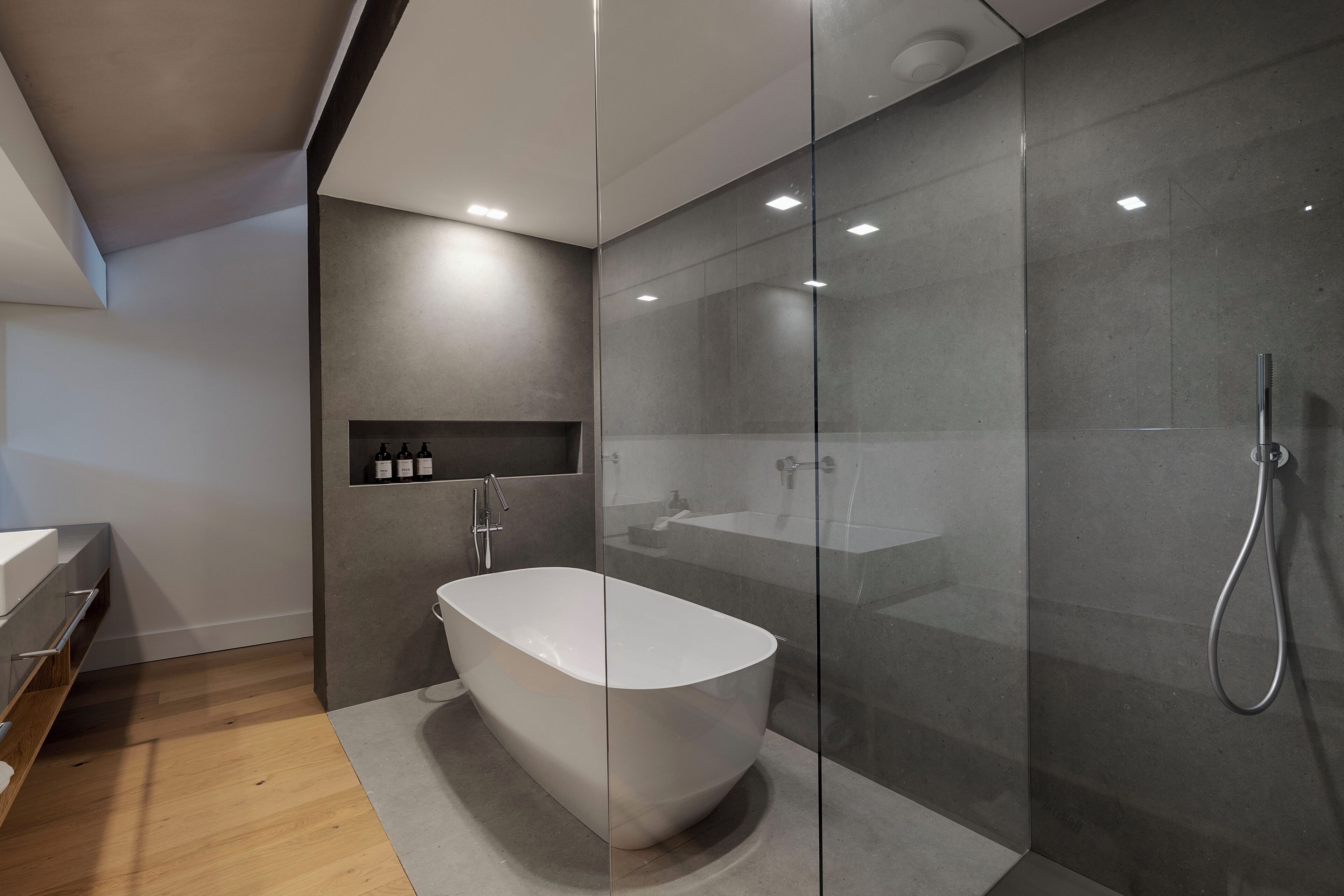 Un bagno moderno con una vasca freestanding, un box doccia in vetro e un mobile lavabo con specchio.