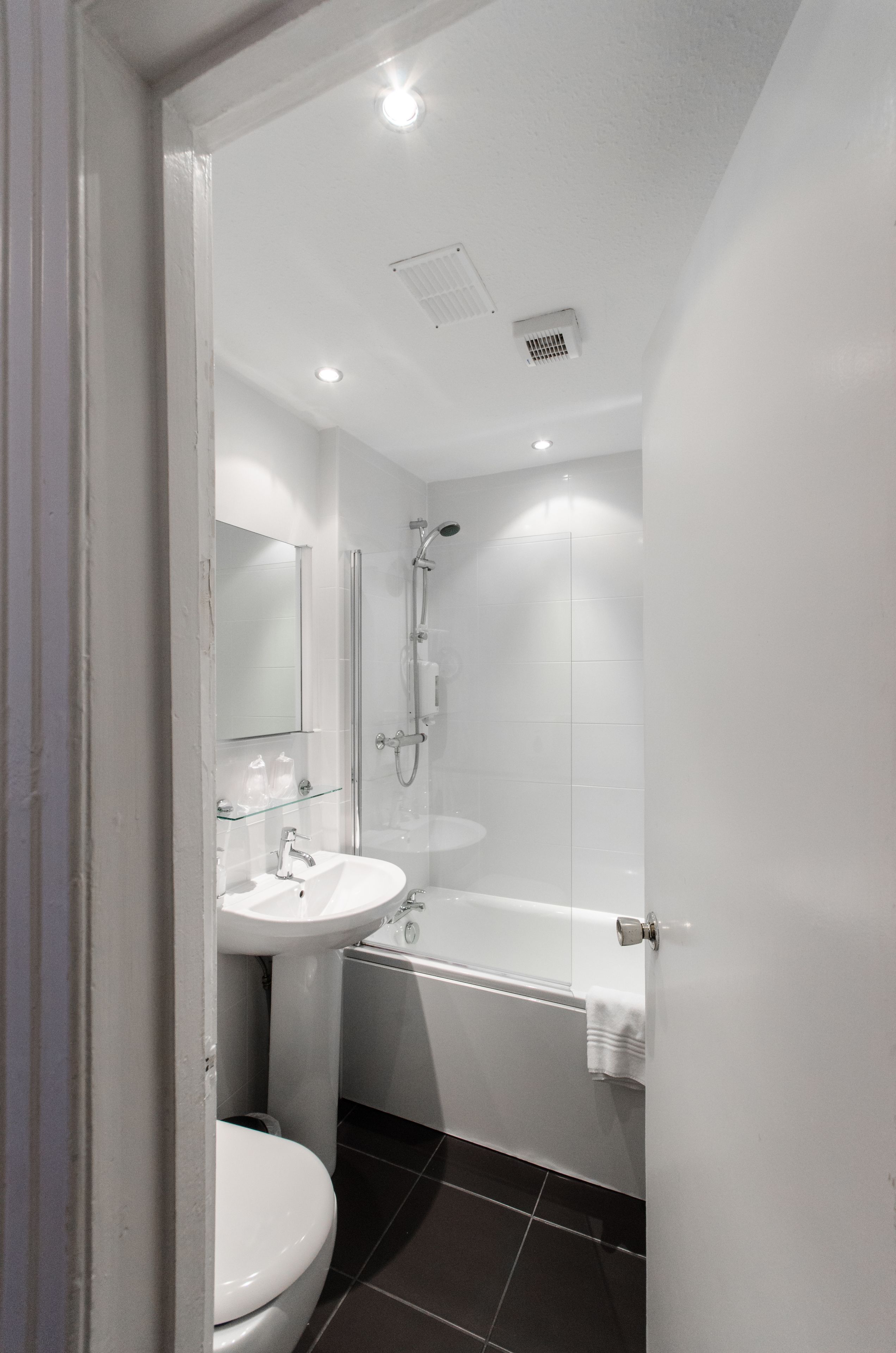 Een moderne badkamer met toilet, wastafel en douche.
