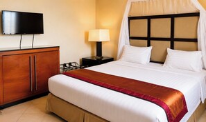 Une chambre d’hôtel équipée d’un lit, d’une télévision, d’une table de chevet, d’une lampe et d’une armoire.
