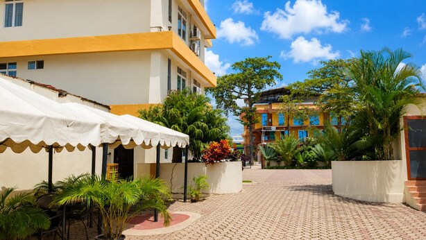 Un patio con un sendero empedrado, mobiliario exterior y plantas en macetas.
