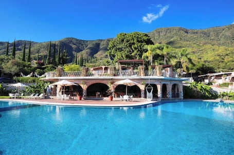 Una piscina al aire libre, sombrillas, tumbonas. Mama Chuy Hotel & Villas Ajijic