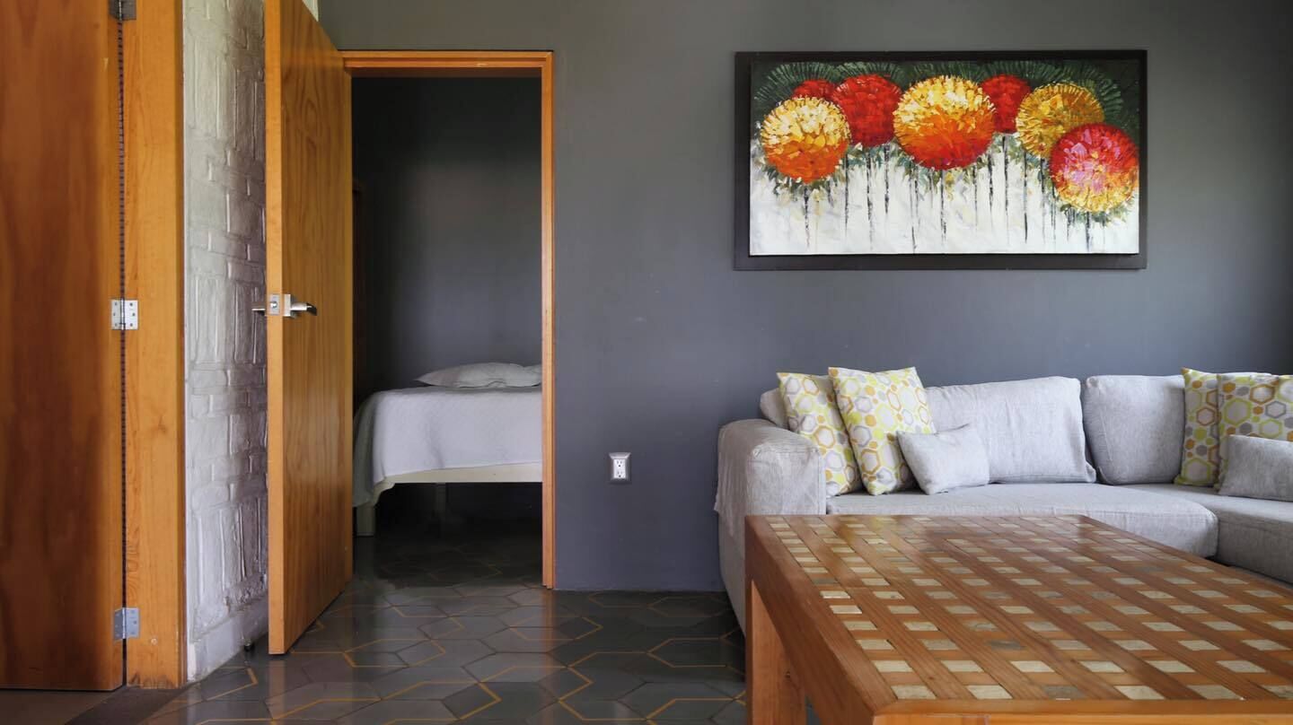 Ein Zimmer mit einem Bett, einer Couch und einem floralen Bild an der Wand.