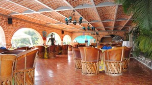 Ein Restaurant mit Ziegelbögen, Holzkubaturen und einem Fliesenboden.
