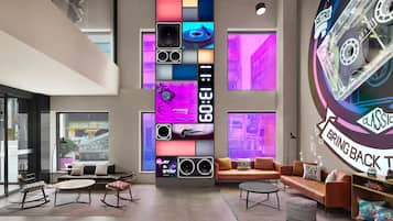 A modern interior with a large wall display, seating area, and a retro-themed wall art piece.