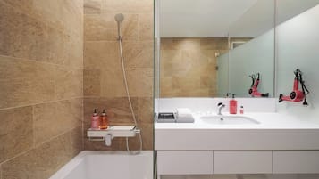 A modern bathroom with a bathtub, a shower, a sink, and a mirror.