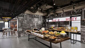 A buffet area with a variety of food items and a 'PLAY @ MOXY' sign on the wall. - Moxy Seoul Insadong (Seoul)