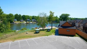 A waterfront property with a parking lot, a small dock, and a row of houses. - Wasaga Riverdocks Hotel Suites (Wasaga Beach)