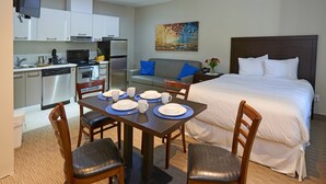 A hotel room with a dining area, kitchenette, and a bed. - Wasaga Riverdocks Hotel Suites (Wasaga Beach)