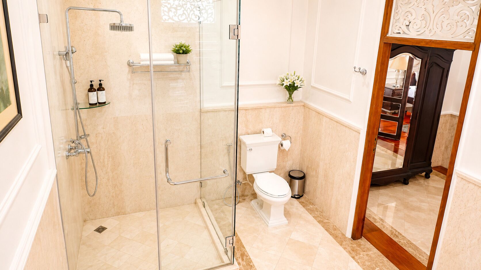 Ein modernes Badezimmer mit einer gläsernen Duschkabine, Toilette und einem kleinen Mülleimer.