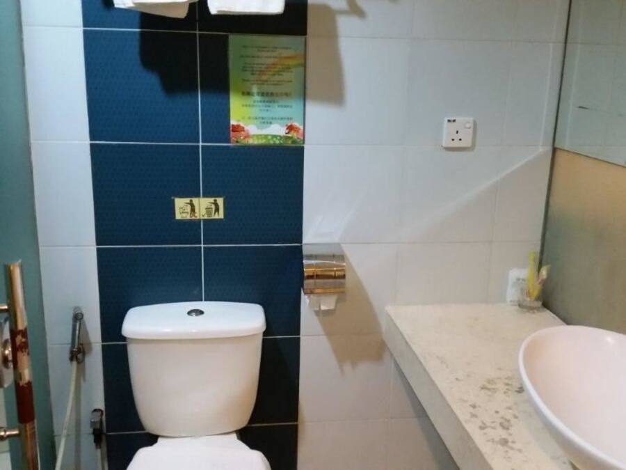 A bathroom with a toilet, a sink, and a shower area.