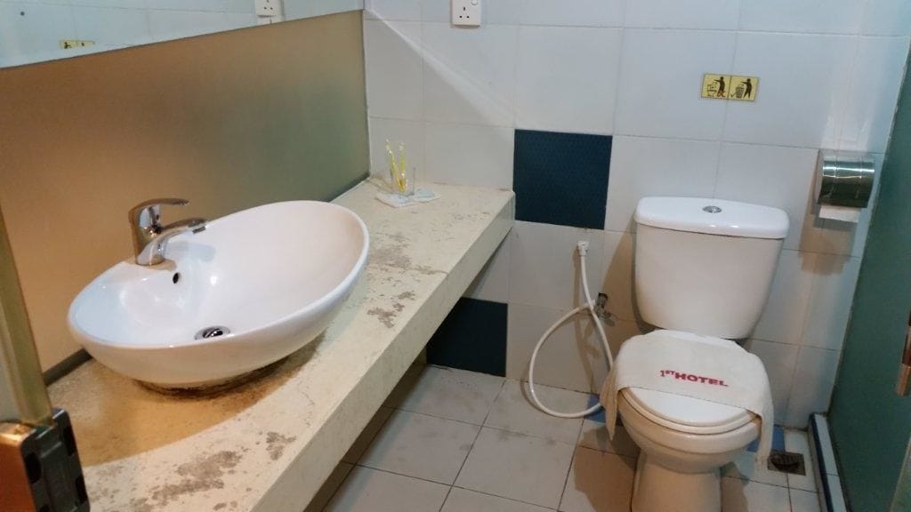 A bathroom with a white sink, a toilet, and a shower.
