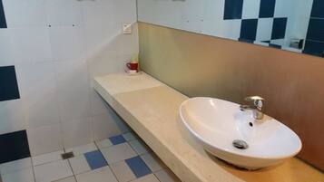 A bathroom with a white sink, a mirror, and a tiled floor.