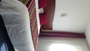 A hotel room with a bed, a window with blinds, and a ceiling light. - Hotel fontaine morlaix  (Morlaix)