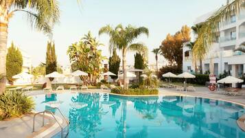 Una piscina al aire libre, sombrillas, tumbonas