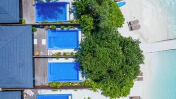 Un resort con diverse piscine, una spiaggia e una vegetazione lussureggiante.