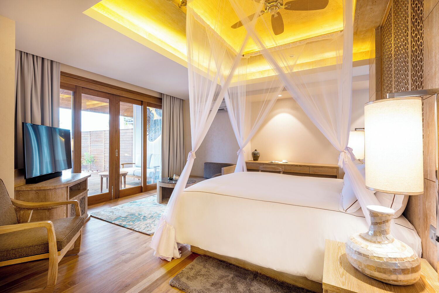 Una habitación de hotel con una cama grande, televisor, escritorio y silla.