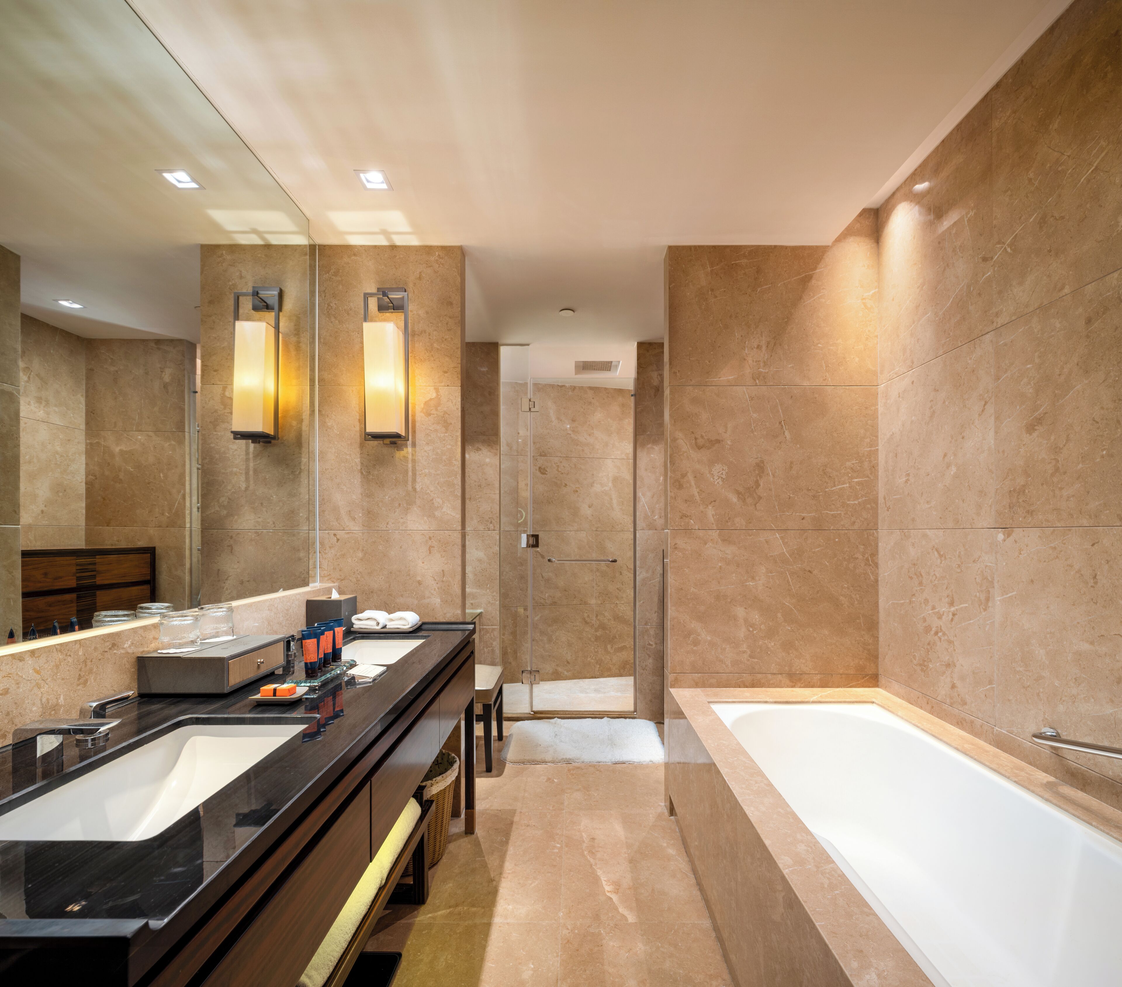 Een moderne badkamer met een grote spiegel, een bad en een douchehoek.